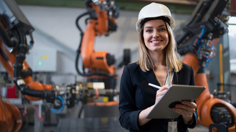 Woman wearing a white hard hat smiling at the camera